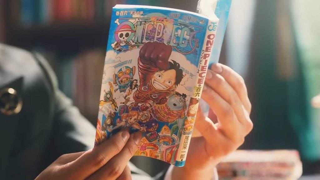 A person reading the One Piece manga volume 106.