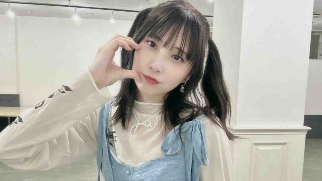 Japanese artist Manako posing with her hand on face making a heart symbol