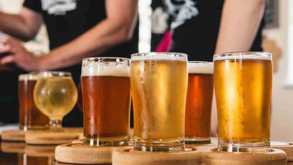 Wooden tasting platter with samples of assorted beer, cider, and mead in Lincoln, CA, USA