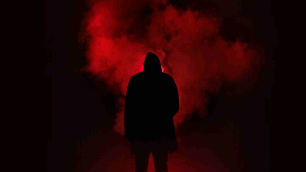 Dark male silhouette against smoky red backdrop