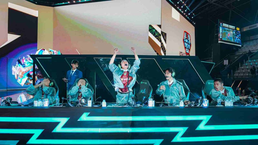 Alter Ego celebrating on stage as they clinch victory in a match