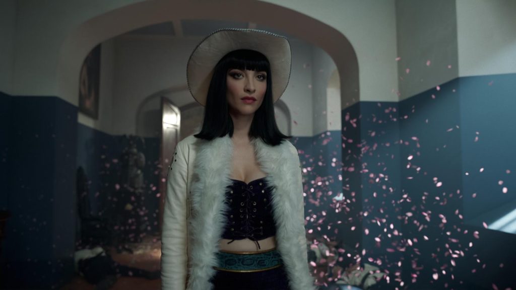 Lera Abova as Miss All Sunday standing with petals floating around her in One Piece live action season 2 episode 1.