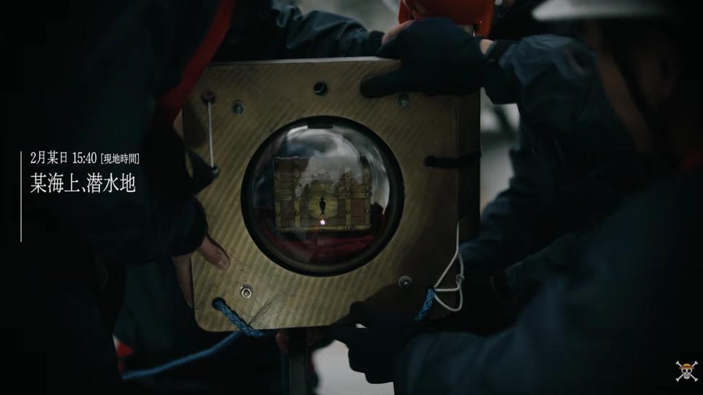 Staff holding the encapsulated One Piece treasure box as they prepare to drop it in the ocean.