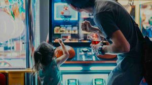 Dad and daughter playing basketball arcade game machine together