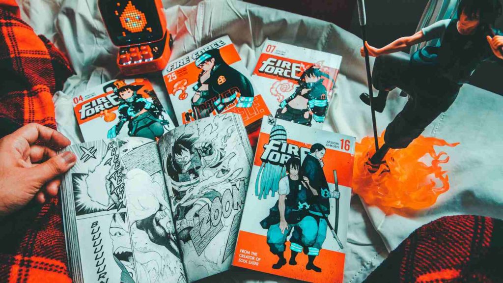 Fan showing his Fire Force fandom collection on his bed comprising manga and an action figure