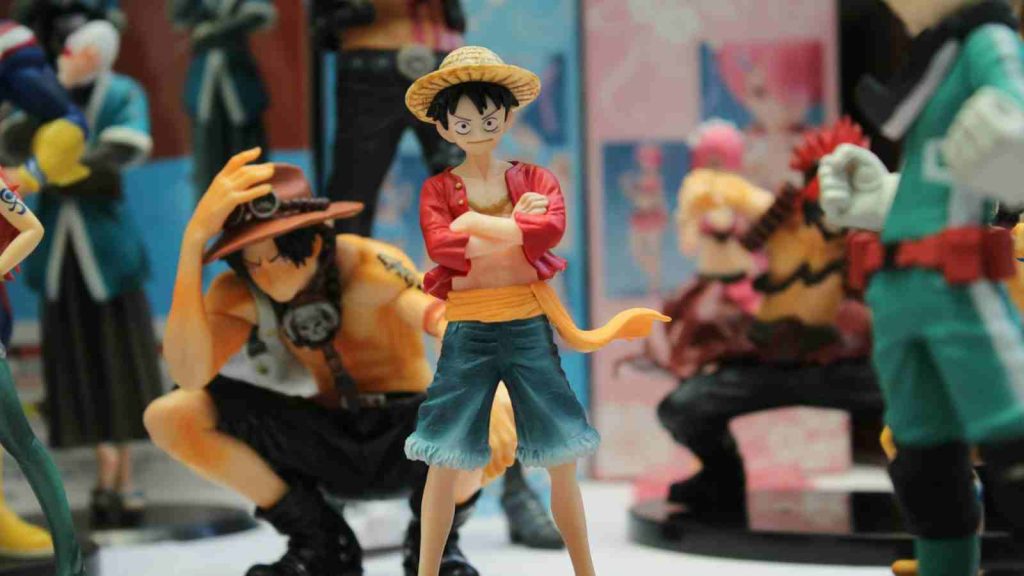 One Piece's Luffy figurine with crossed arms is part of this fan's larger anime figure collection