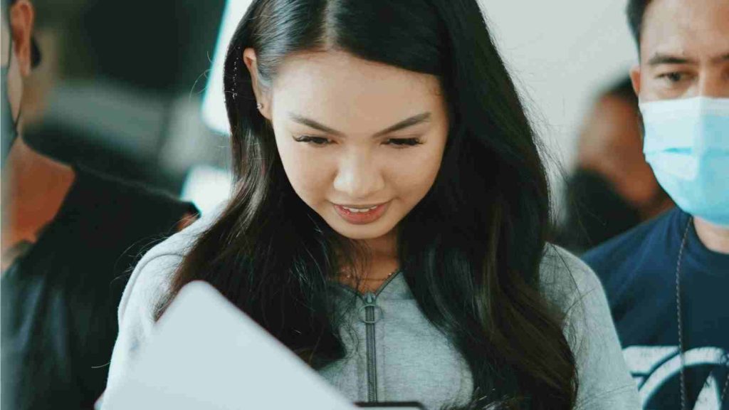 Asian actress reviewing the script in front of the camera before filming starts 