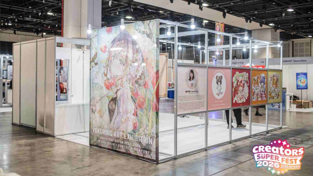 Japanese artist Yukoring's exhibition at AFA CSF 2026 showing a profile of her, a display of her artworks, and merchandise for sale