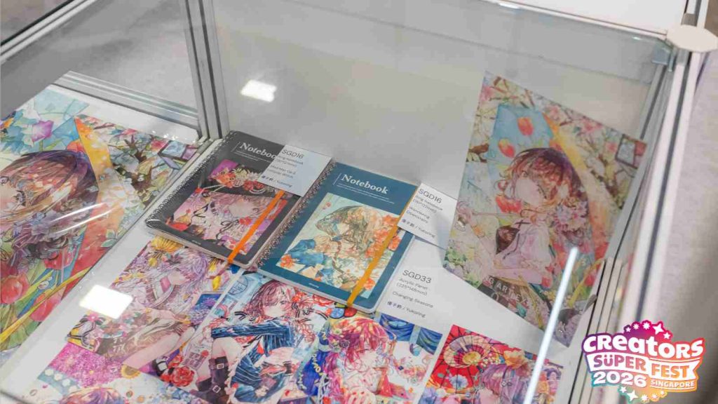 Merchandise such as notebooks and art prints on sale by Japanese artist Yukoring at AFA CSF 2026