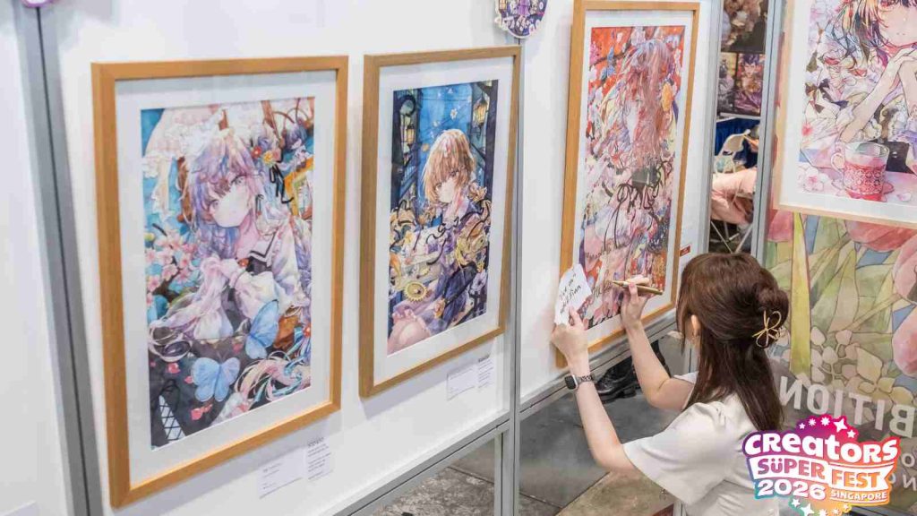 Japanese artist Yukoring signing a sold print at her exhibition at AFA CSF 2026
