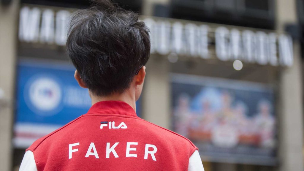 SKT Faker at the Madison Square Garden. Written on his red jacket is his gamertag Faker with the brand sponsor logo, Fila.