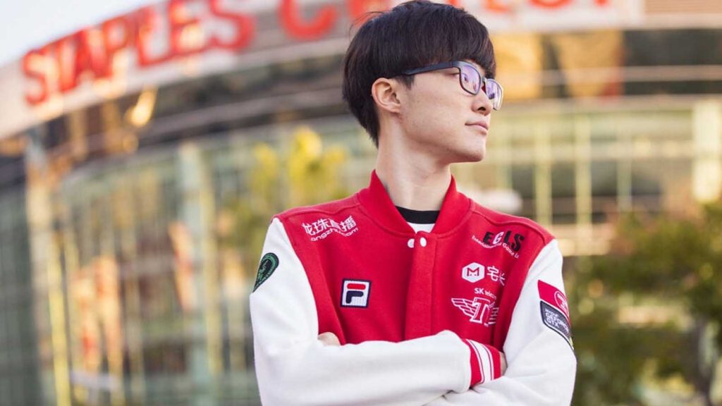 A side view of Faker while wearing his SK Telecom T1 red jacket with the Staples Center on the background.