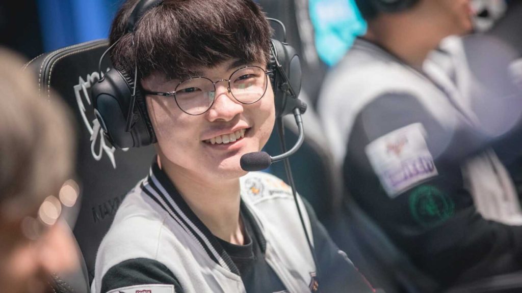 Faker at the League of Legends World Championship smiling while wearing a black and white jacket.