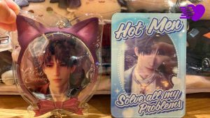 Photograph of Love and Deepspace Rafayel badge and photocard in poca holder as part of oshikatsu fan activity
