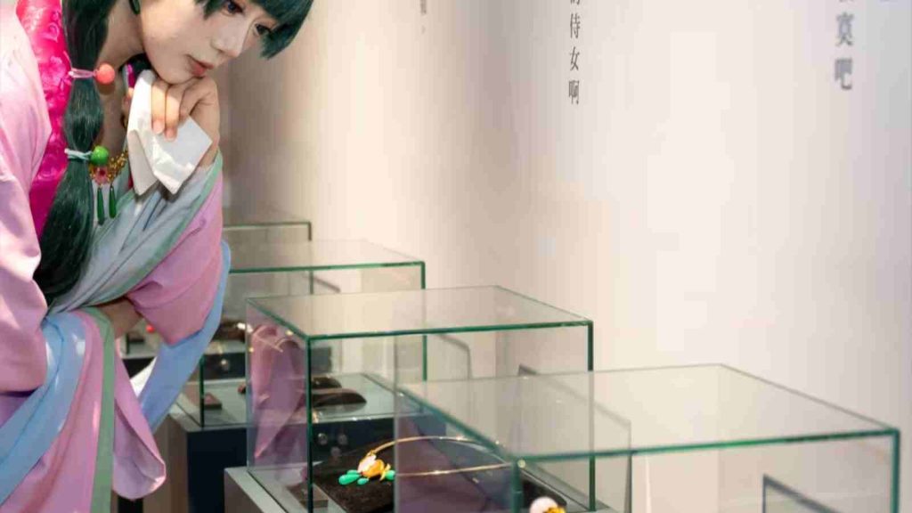 Maomao cosplayer looking at the jewelry displays at The Apothecary Diaries Exhibition 