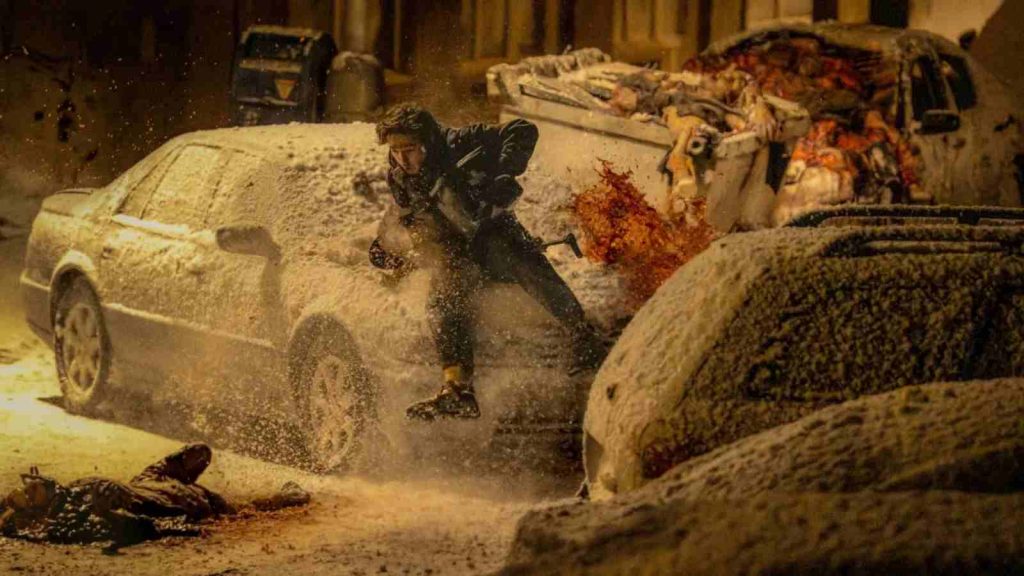 Bryan running for his life in Racoon City during the winter while holding a gun in Resident Evil 2026 movie