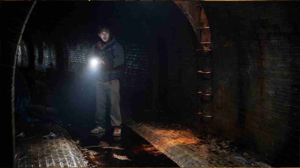 Bryan navigating the Racoon City sewers using the flashlight in his phone in Resident Evil 2026 movie